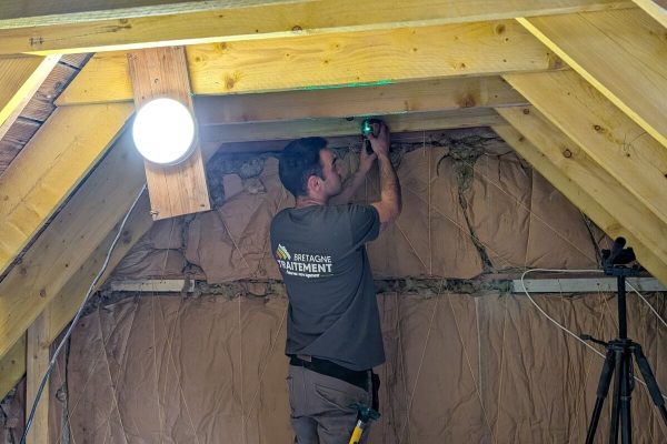 Technicien mesurant l’isolation dans des combles aménagés